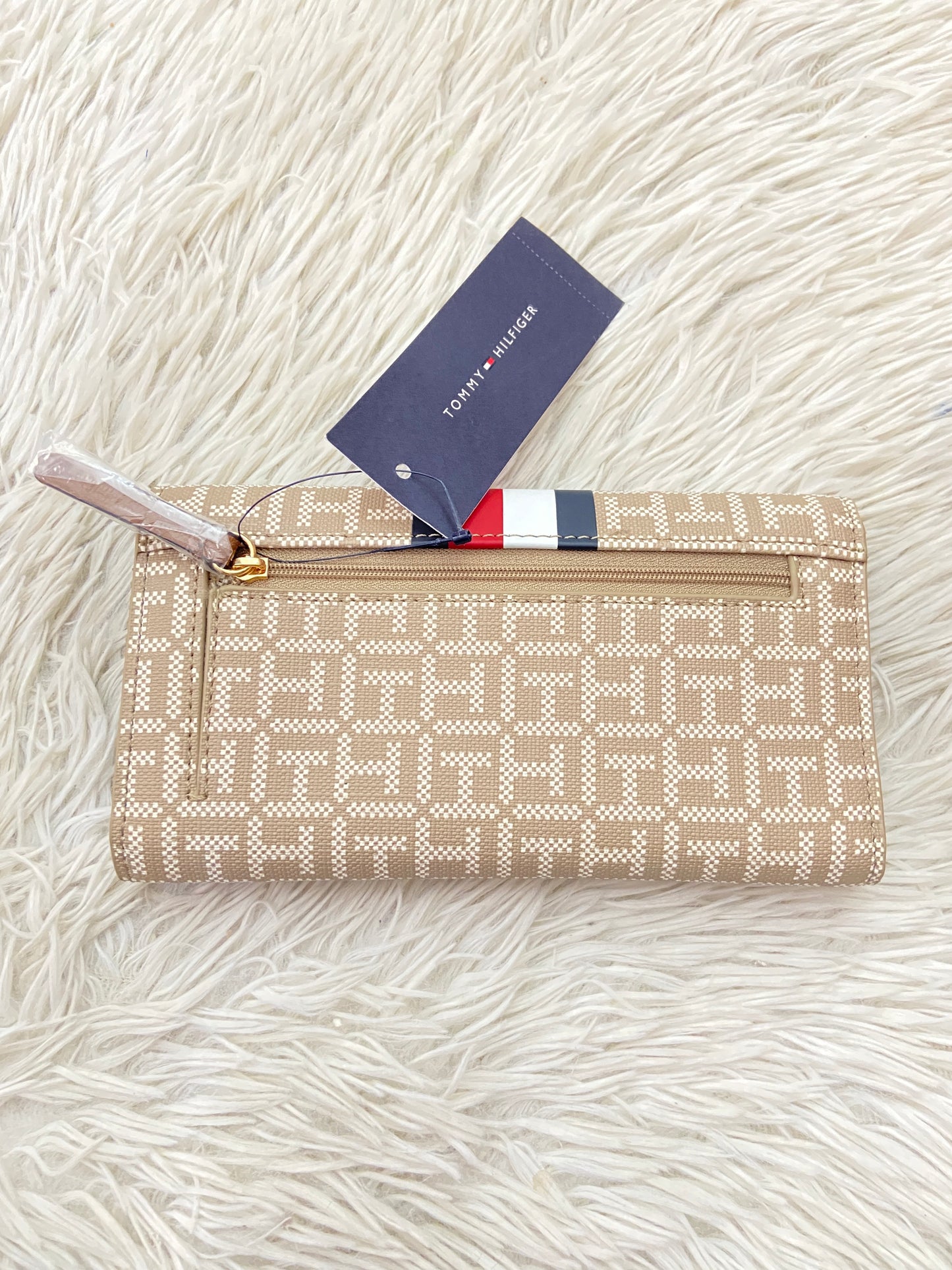 Monedero Tommy Hilfiger original marrón con estampado del logo de Tommy y franja azul, rojo y blanco, placa TH en dorado.