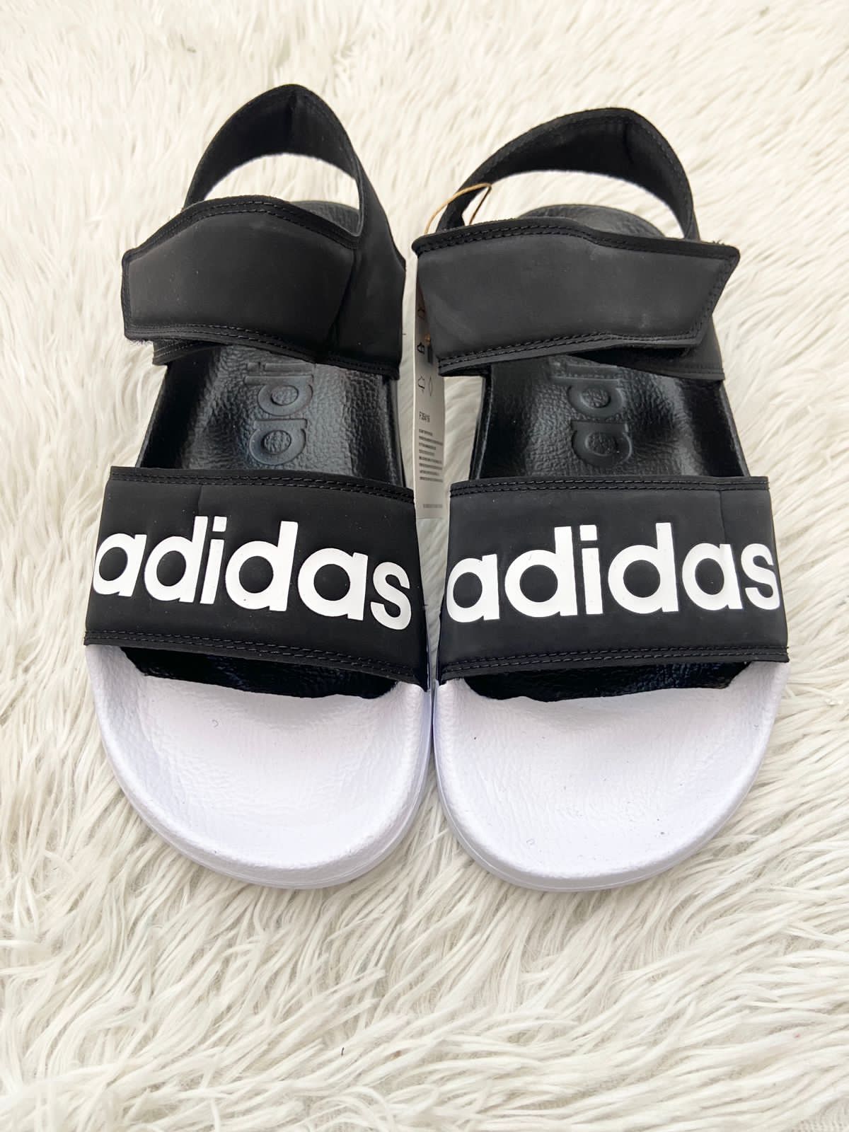 Sandalias ADIDAS ORIGINAL negra letras Adidas color blanco en el centro.