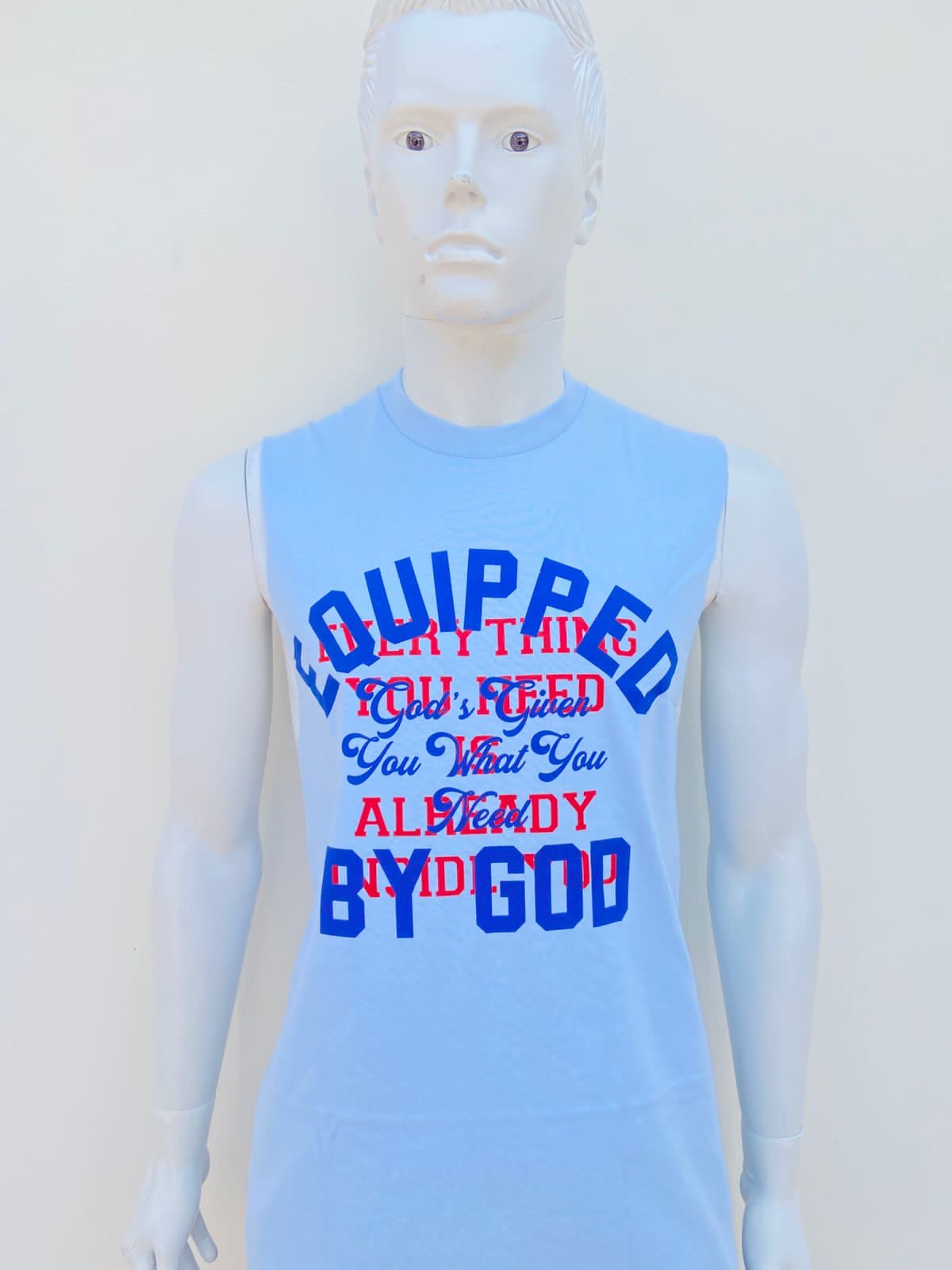 Franela azul con letras en color azul y rojo al frente, EQUIPPED BY GOD.