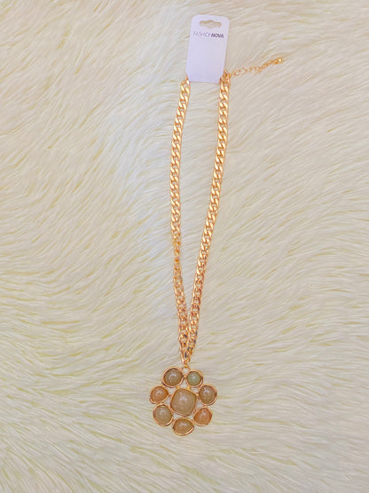 Cadena, dorada con dije en forma de flor y piedras verde.