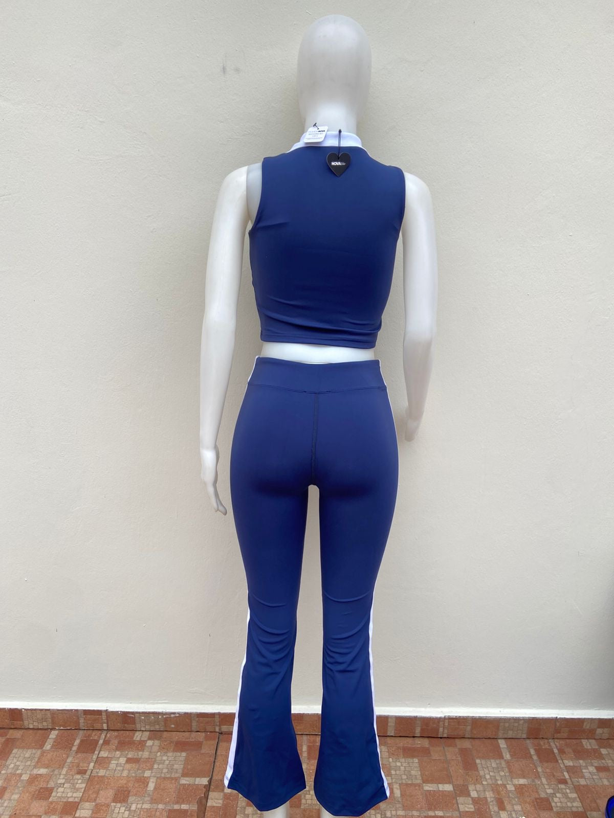 Conjunto top y legging en color azul marino con lineas blancas en los lados, top sin mangas y cuello blanco.