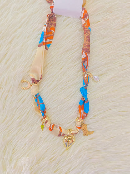 Collar de paño con accesorios colgantes de perlas, corazones y zapatos de vaqueros.