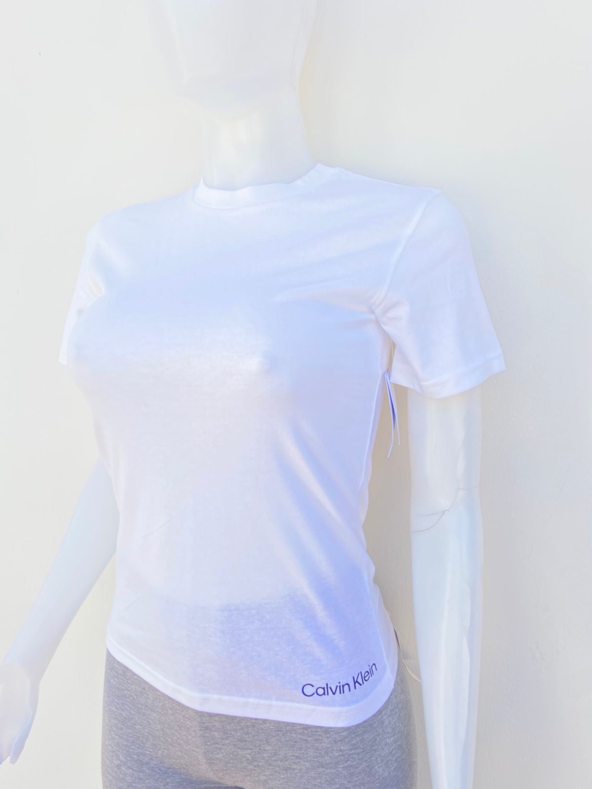 T-shirt CALVIN KLEIN original blanco liso con  letra CALVIN KLEIN en negro en la parte inferior.