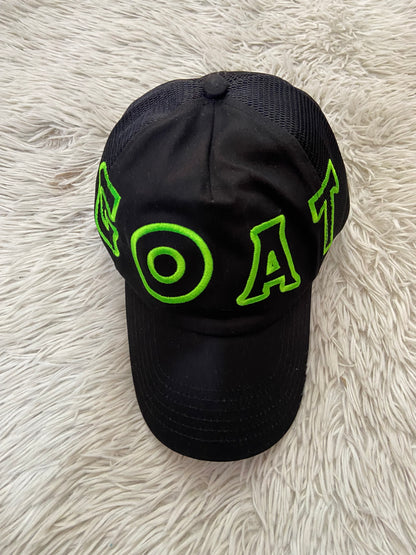 Gorra negra con letras GOAT en verde ( la cabra )