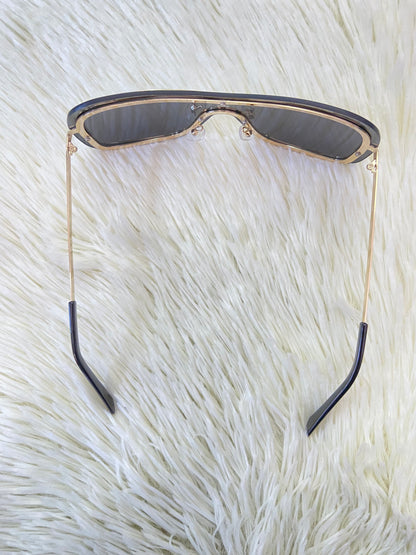 Lentes, negros, grandes curvos, con línea dorada al rededor y montura en  dorado.