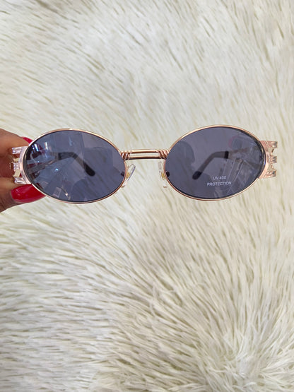 Lentes, negros con montura dorada, estilo ovalo, con protección UV 100-400.