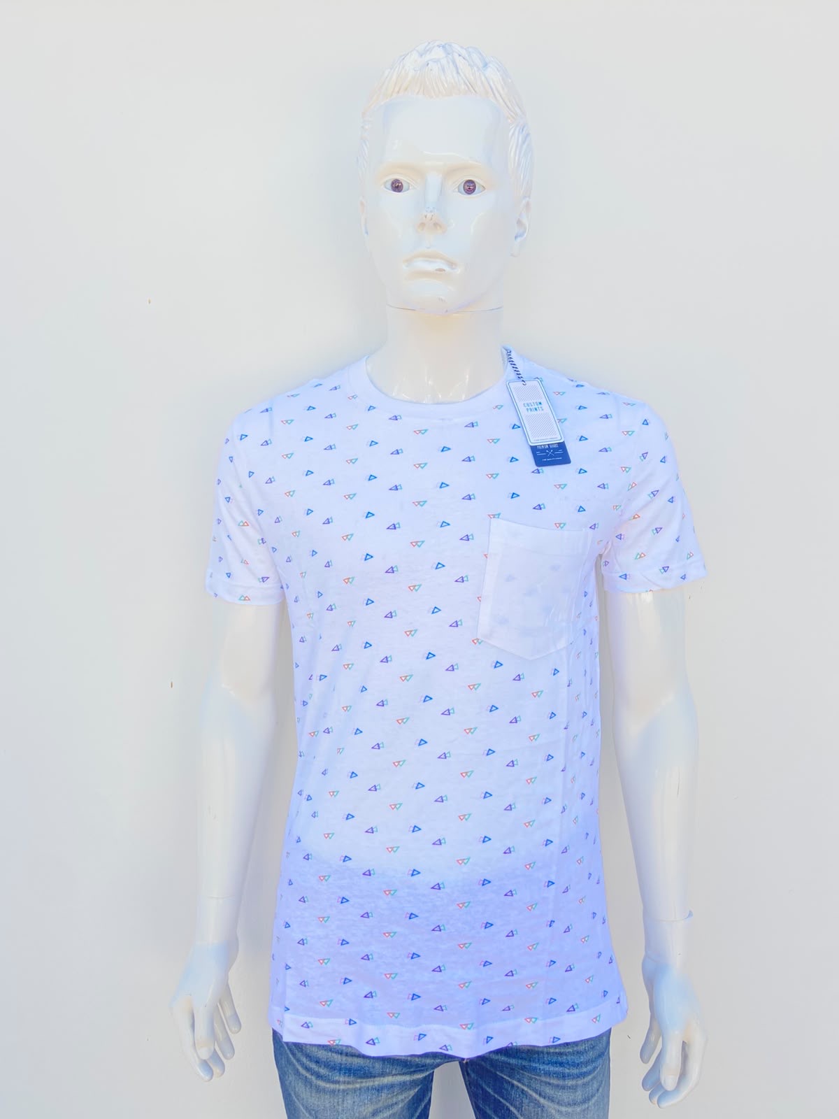 T-shirt MBX PREMIUM GOODS original, blanco con estampado de pequeños triángulos en color verde, morado, rosado y verde y bolsillo al frente, 100% algodón