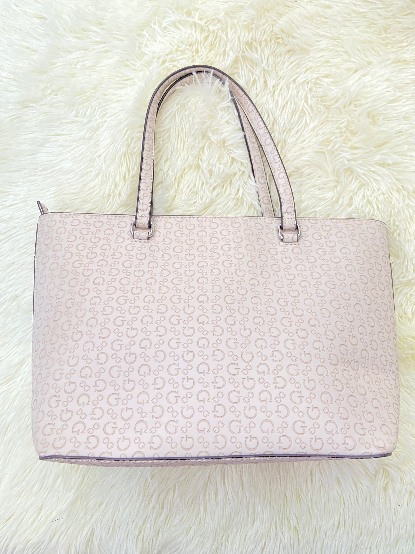 Cartera GUESS original, grande, rosado palo crema con letras G y placa GUESS en plateado en frente.