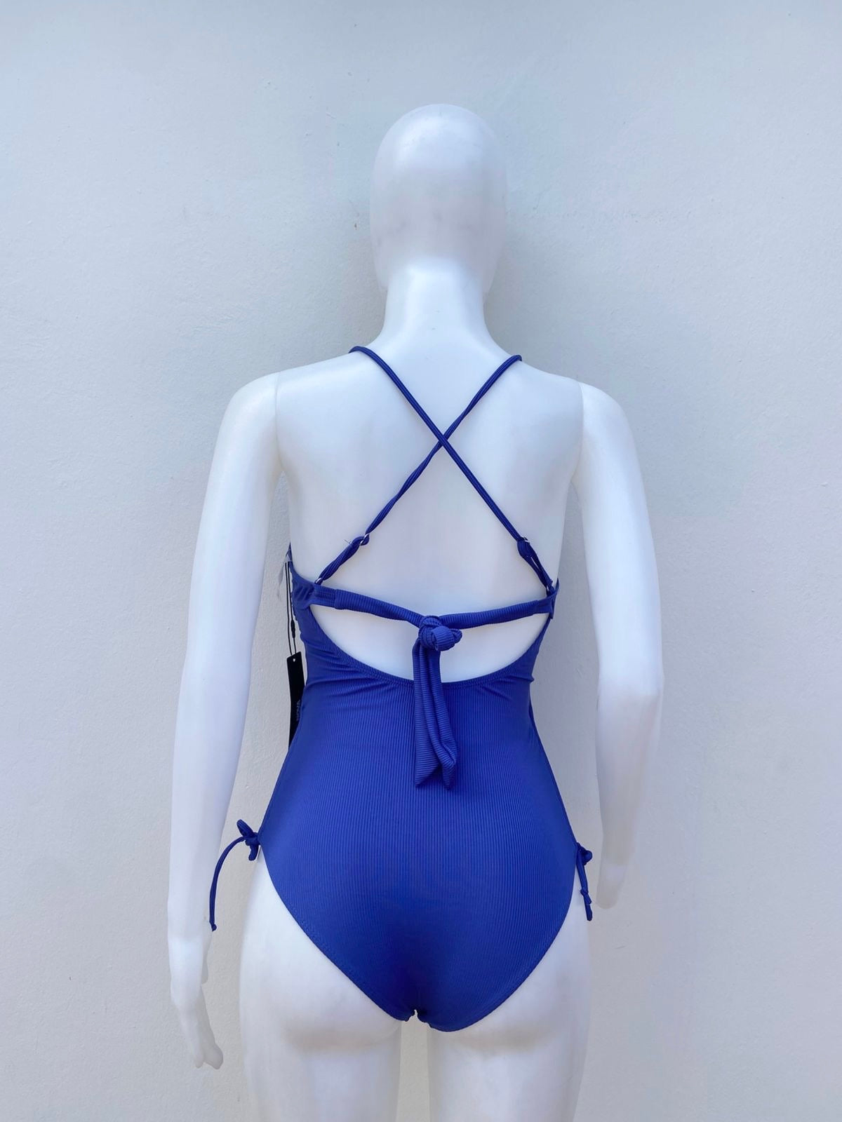 Biquini, azul navy con abierto en frente, lazos cruzados y lazos ajustables en los lados, una pieza.