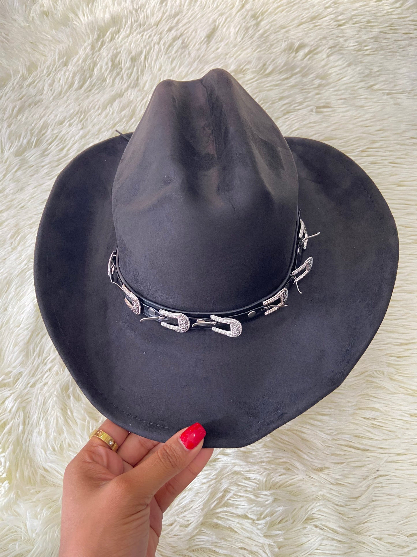 Sombrero, negro con correa y hebillas en color plateado, estilo vaquero.