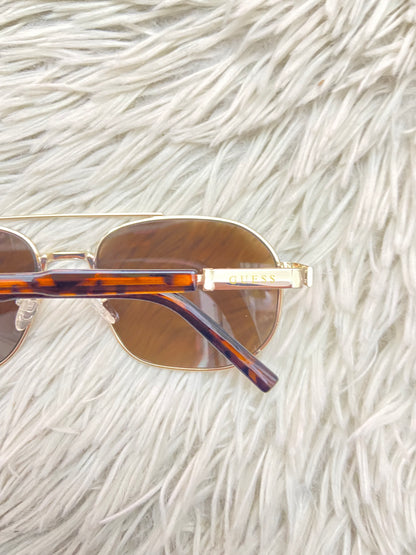 Lentes GUESS original, diseñados con protección UV 100-400 para proteger tu visión. Marrones con montura en animal print, ovalados.