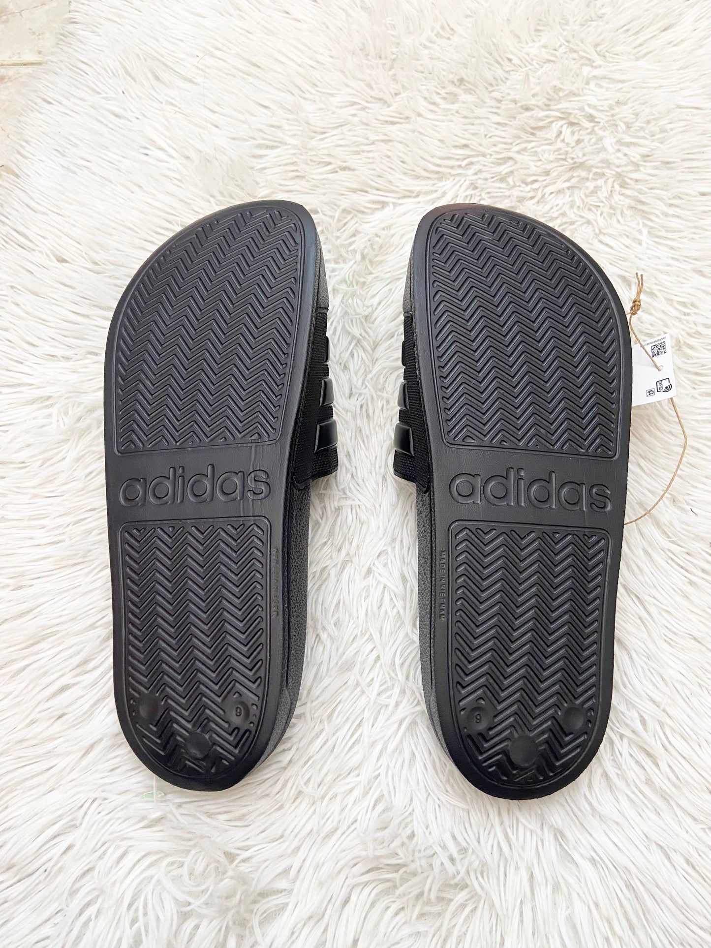 Sandalias Adidas original negra lisa con líneas en color negro en frente y letras ADIDAS al lado.