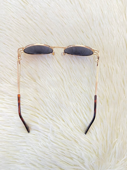Lentes, negros con montura dorada, estilo ovalo, con protección UV 100-400.