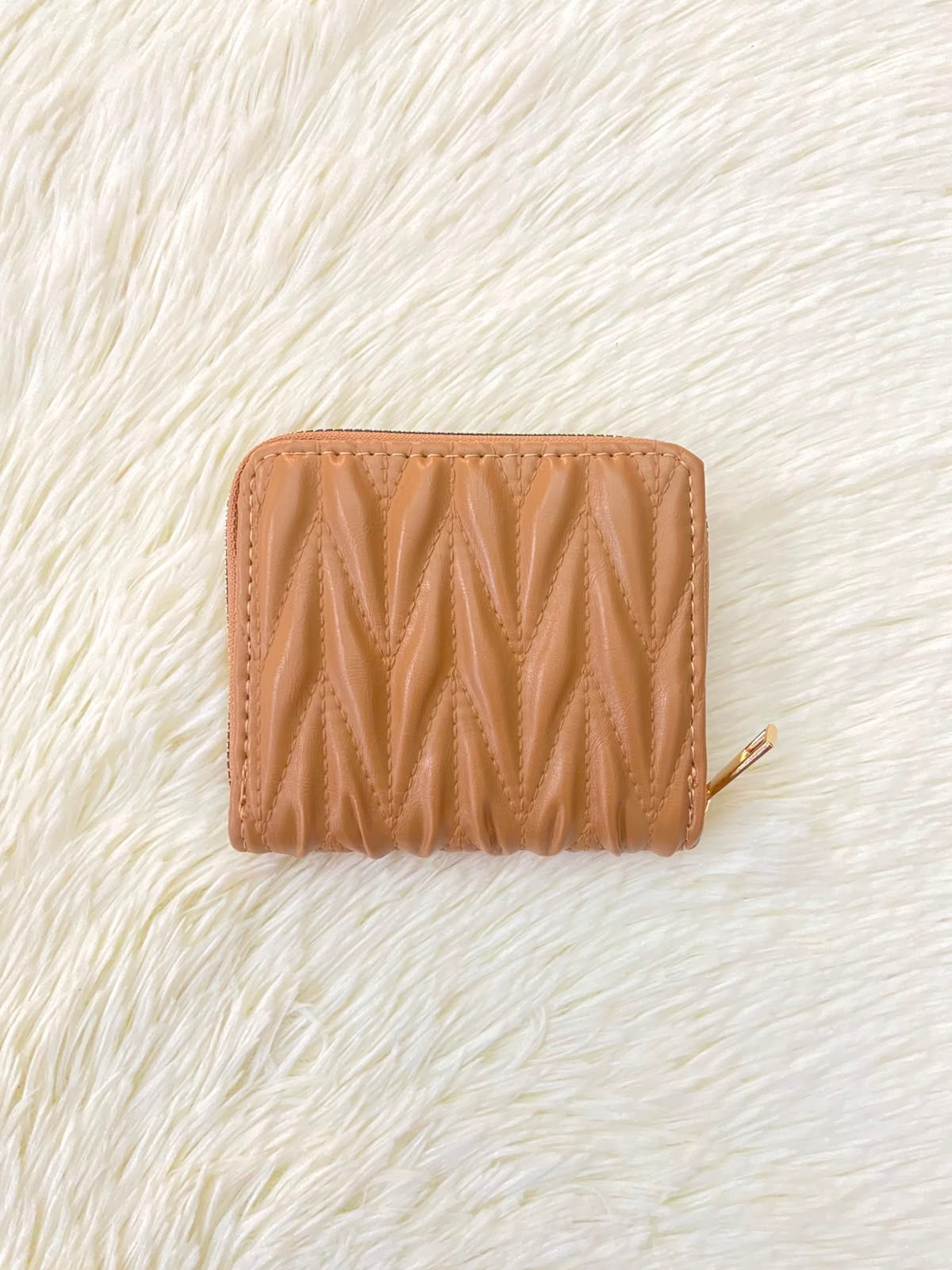 Monedero color marrón con diseño acolchado, cierre de zíper y espacio para tarjetas y más.