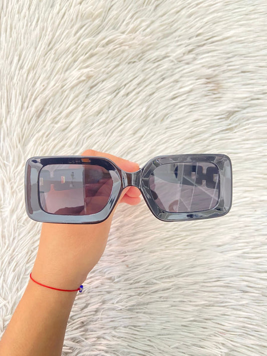 Lentes negros con detalles dorados atras, cuadrados y micas oscuras