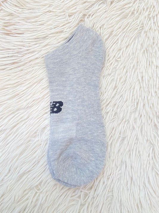 Medias NEW BALANCE original, gris claro con logotipo de la marca en frente.