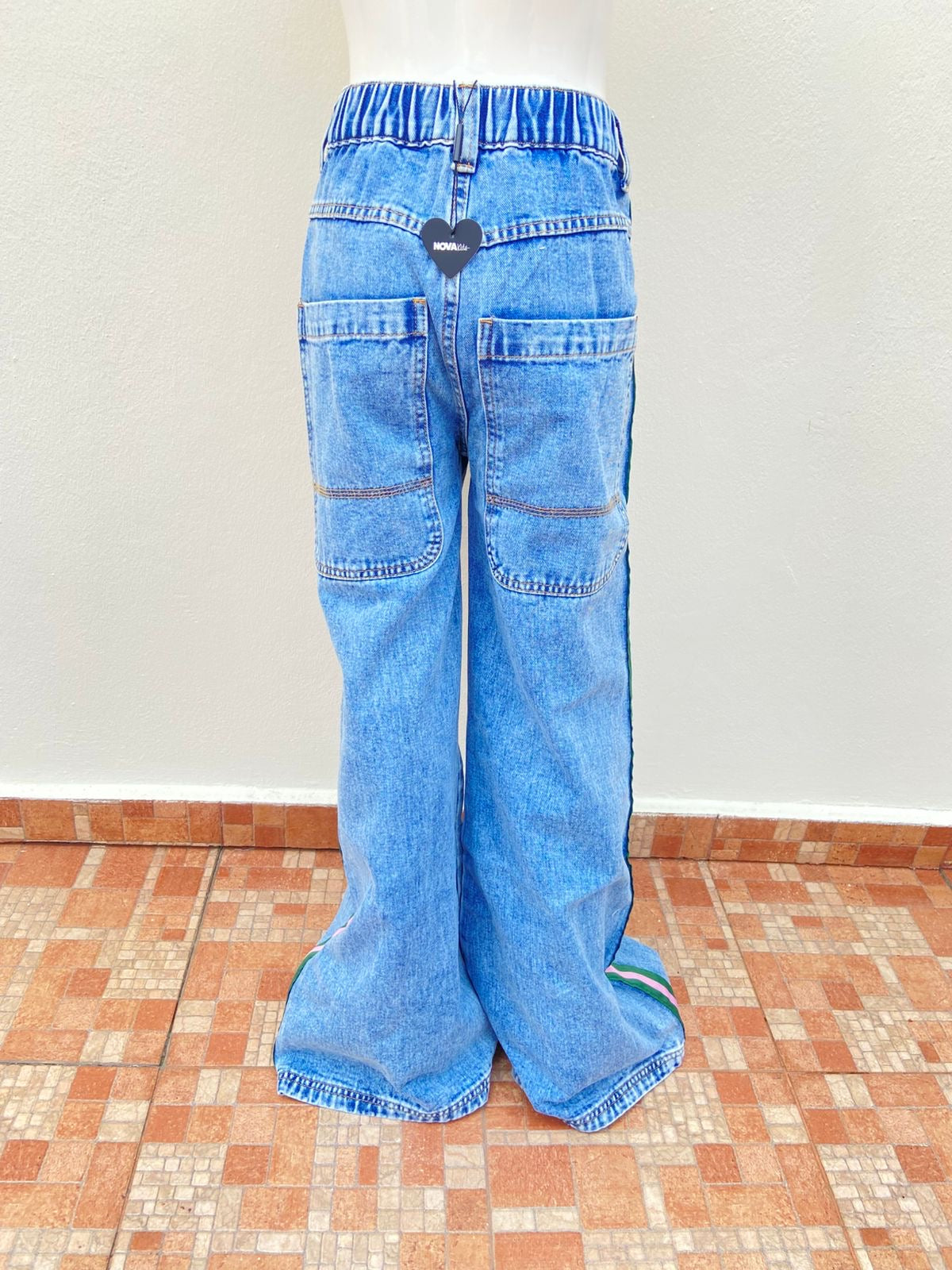 Pantalon jean en color azul claro con lineas de color verde y rosado en los lados, super ancho abajo.