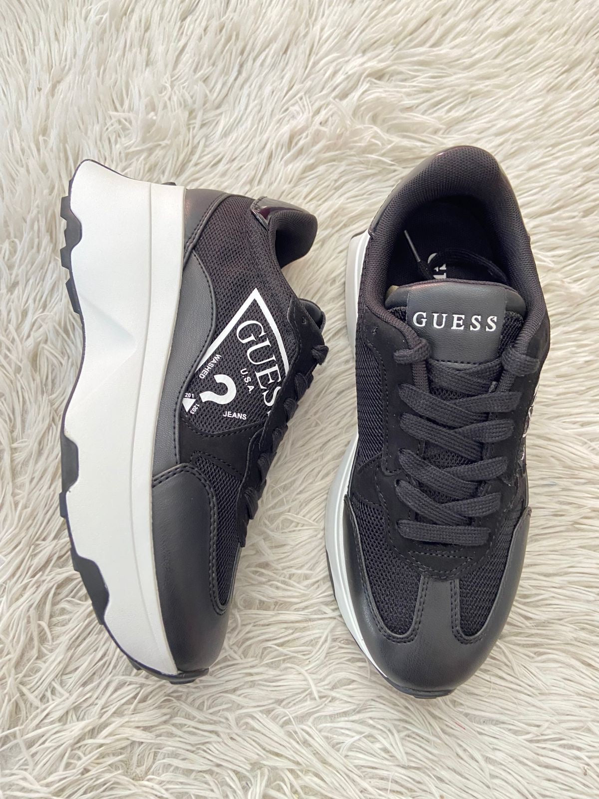 Tenis GUESS original negro, con suelas altas en color blanco y letras “ GUESS ? “ en blanco.