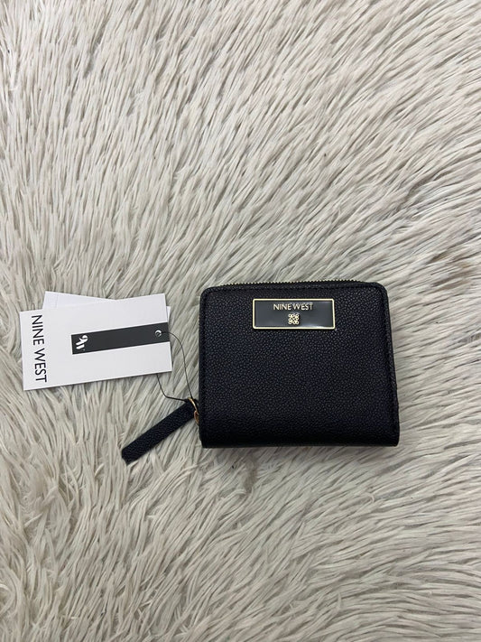 Monedero NINE WEST Original en color negro con placa de la marca al frente en color dorada, siper dorado y varios compartimientos.