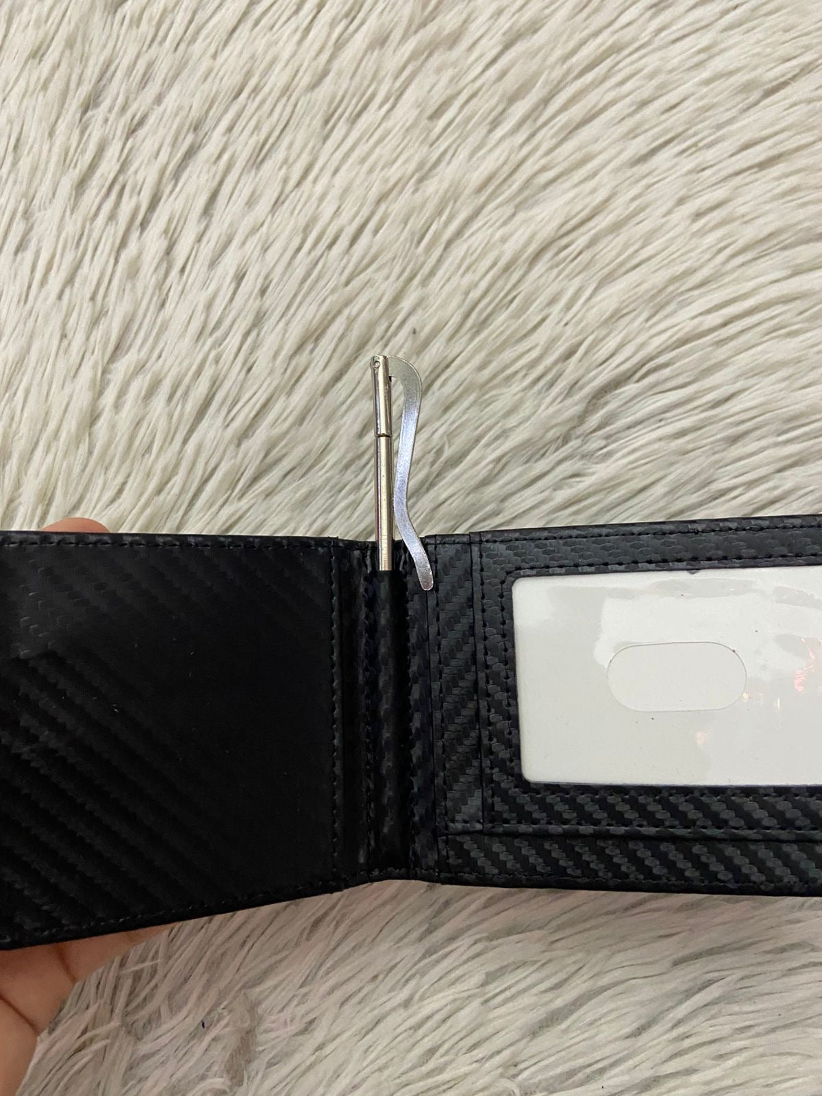 Billetera pequeña en color negra con clip para billetes, espacios para tarjetas y espacio transparente para cedula o licencia.