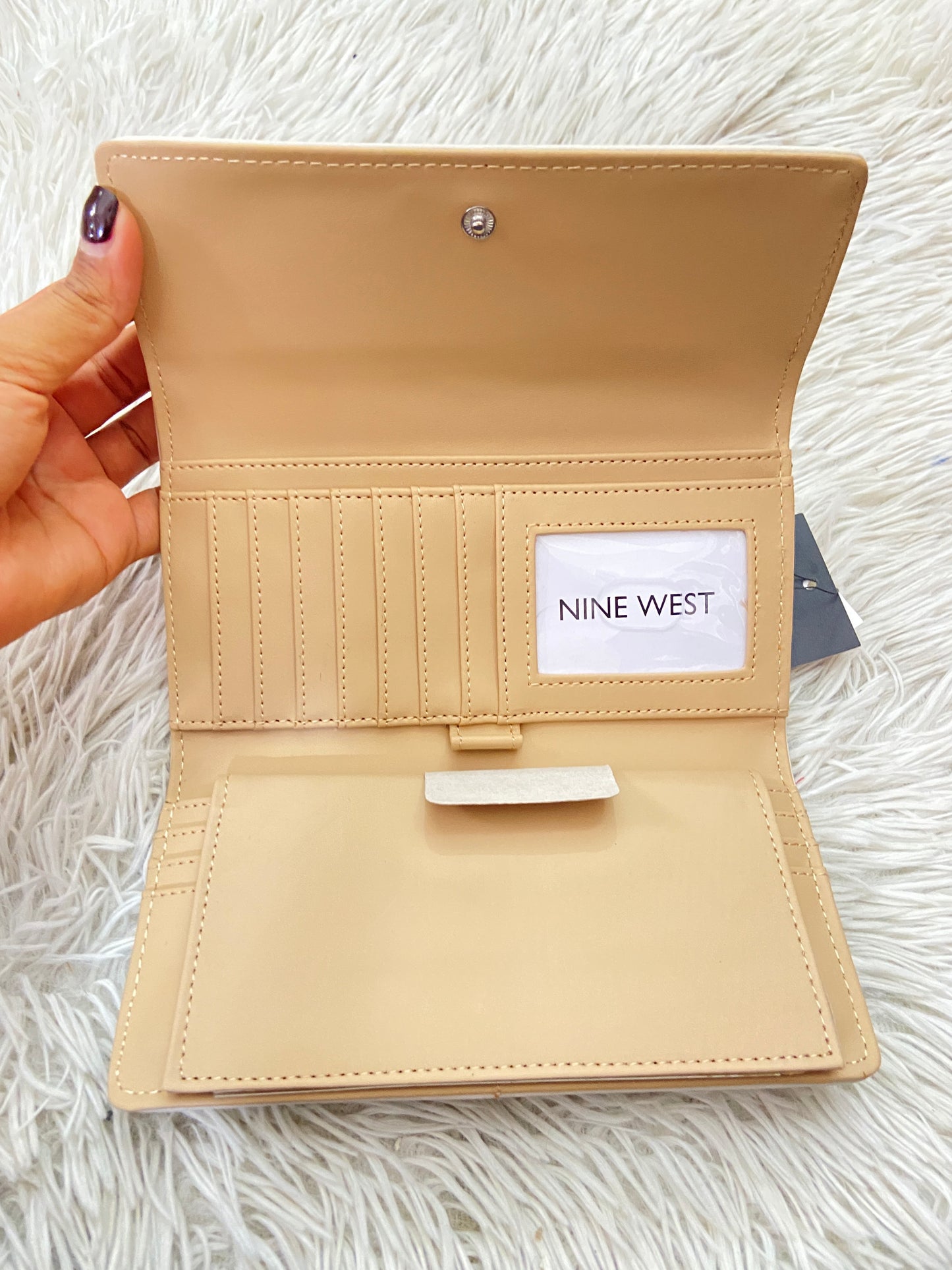 Monedero NINE WEST original crema con estampado de la marca y placa plateada.