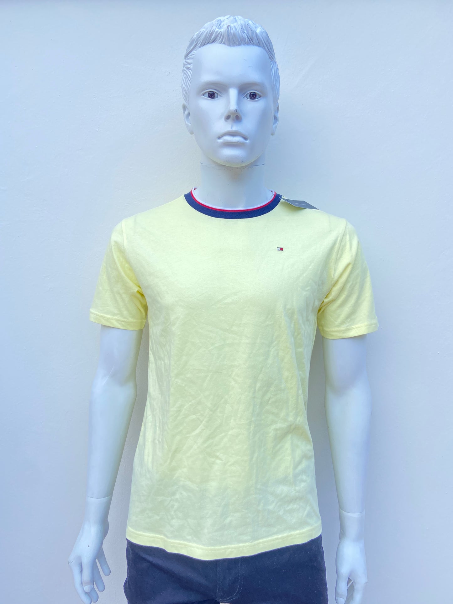 T-shirt Tommy Hilfiger Amarillo claro con logotipo de la marca al lado y cuello en color azul, rojo y blanco.