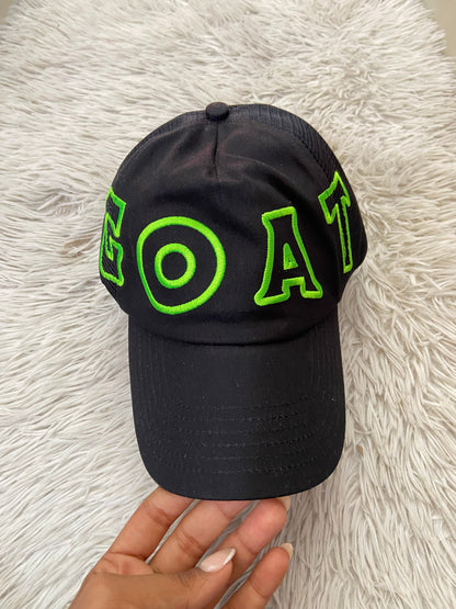 Gorra negra con letras GOAT en verde ( la cabra )