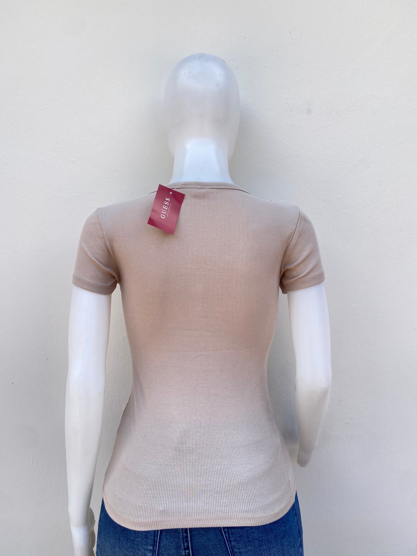 T-shirt GUESS original, crema ( beige ) con letras GUESS en cursivas en dorado y botones plateados.