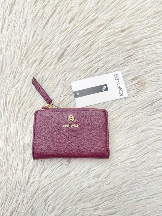 Monedero NINE WEST Original en color rojo vino con placa de la marcs al frente en color dorado, Varios compartimentos y super espaciosa.