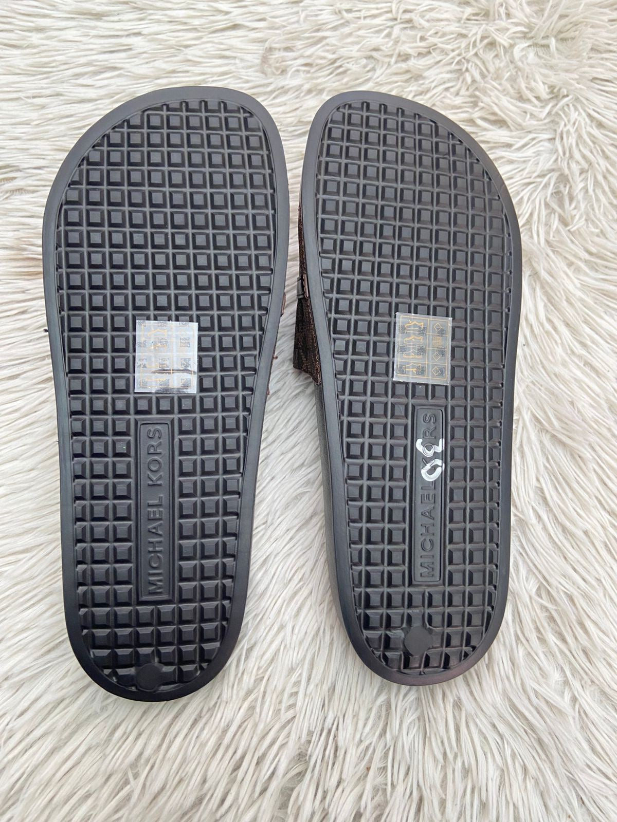 Sandalias MICHAEL KORS original, negra con marrón y correa en frente con placa MK en dorado.