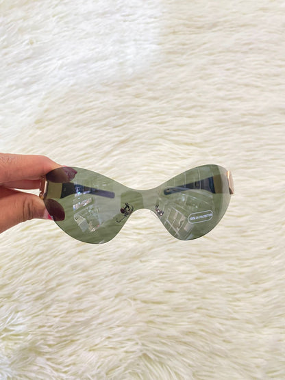 Lentes con micas verde y detalle en color dorado atrás.