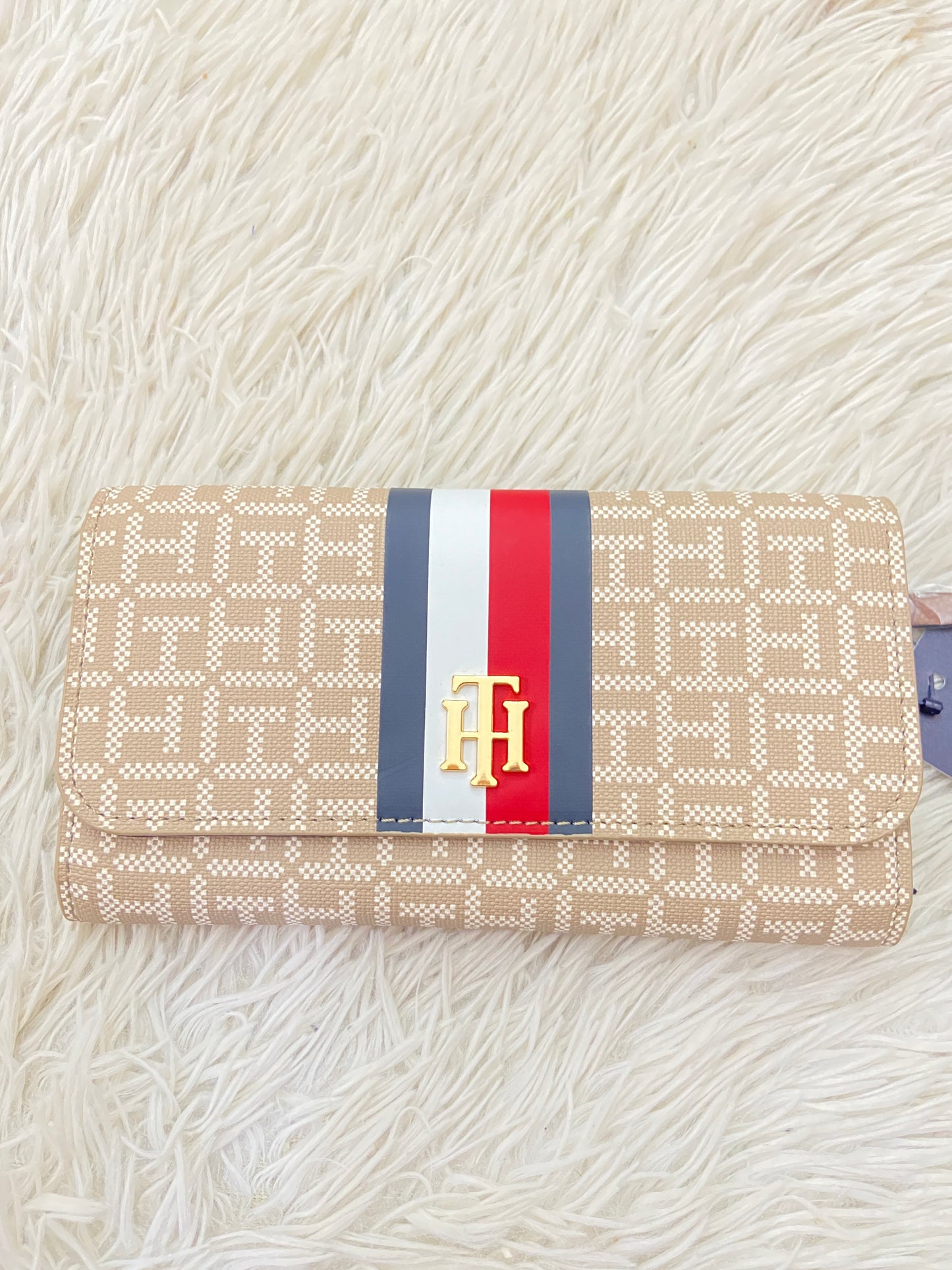 Monedero Tommy Hilfiger original marrón con estampado del logo de Tommy y franja azul, rojo y blanco, placa TH en dorado.