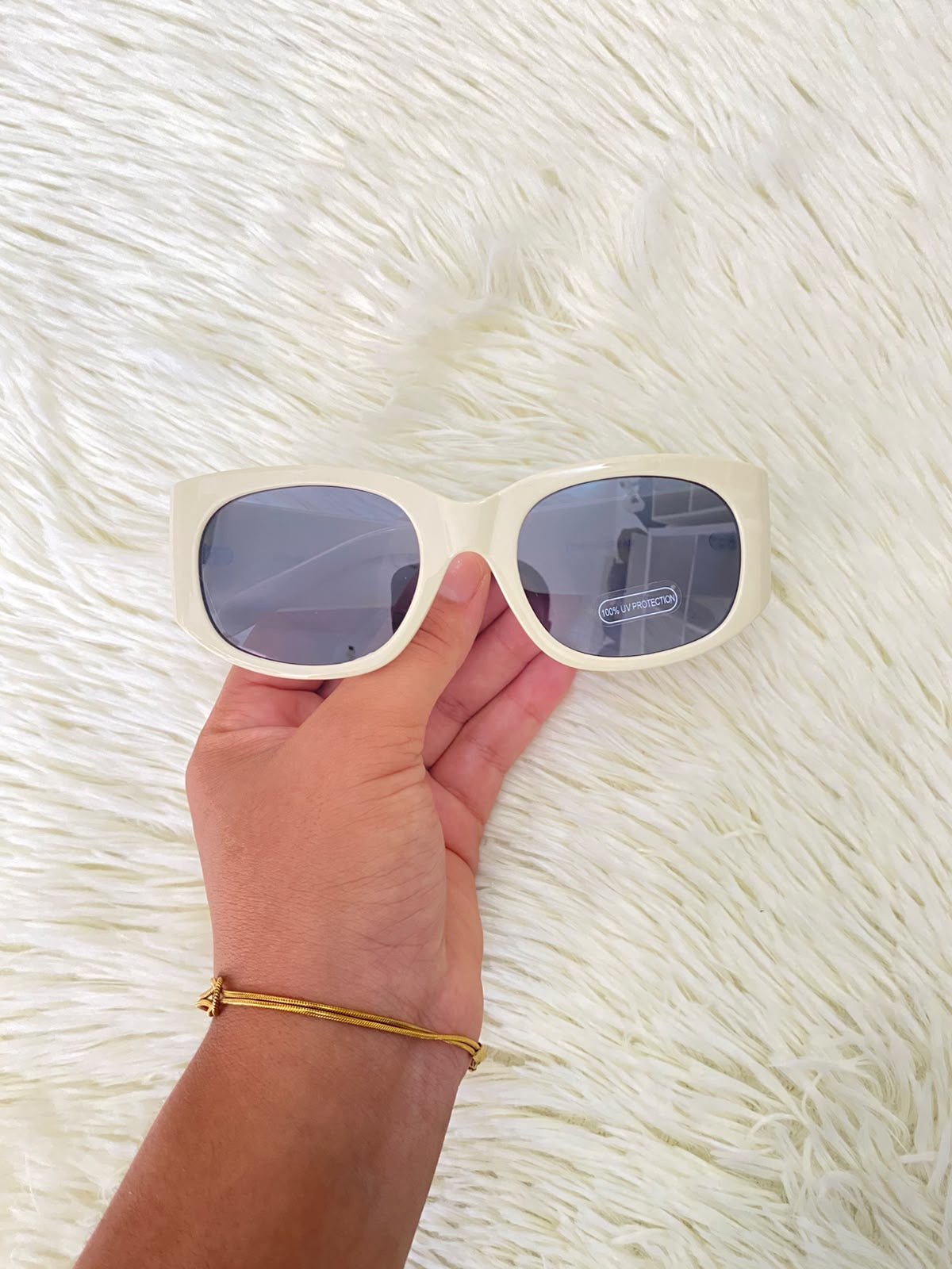 Lentes color crema con estampado de hojas tropicales en las patillas, estilo rectangular, con protección UV 100%.