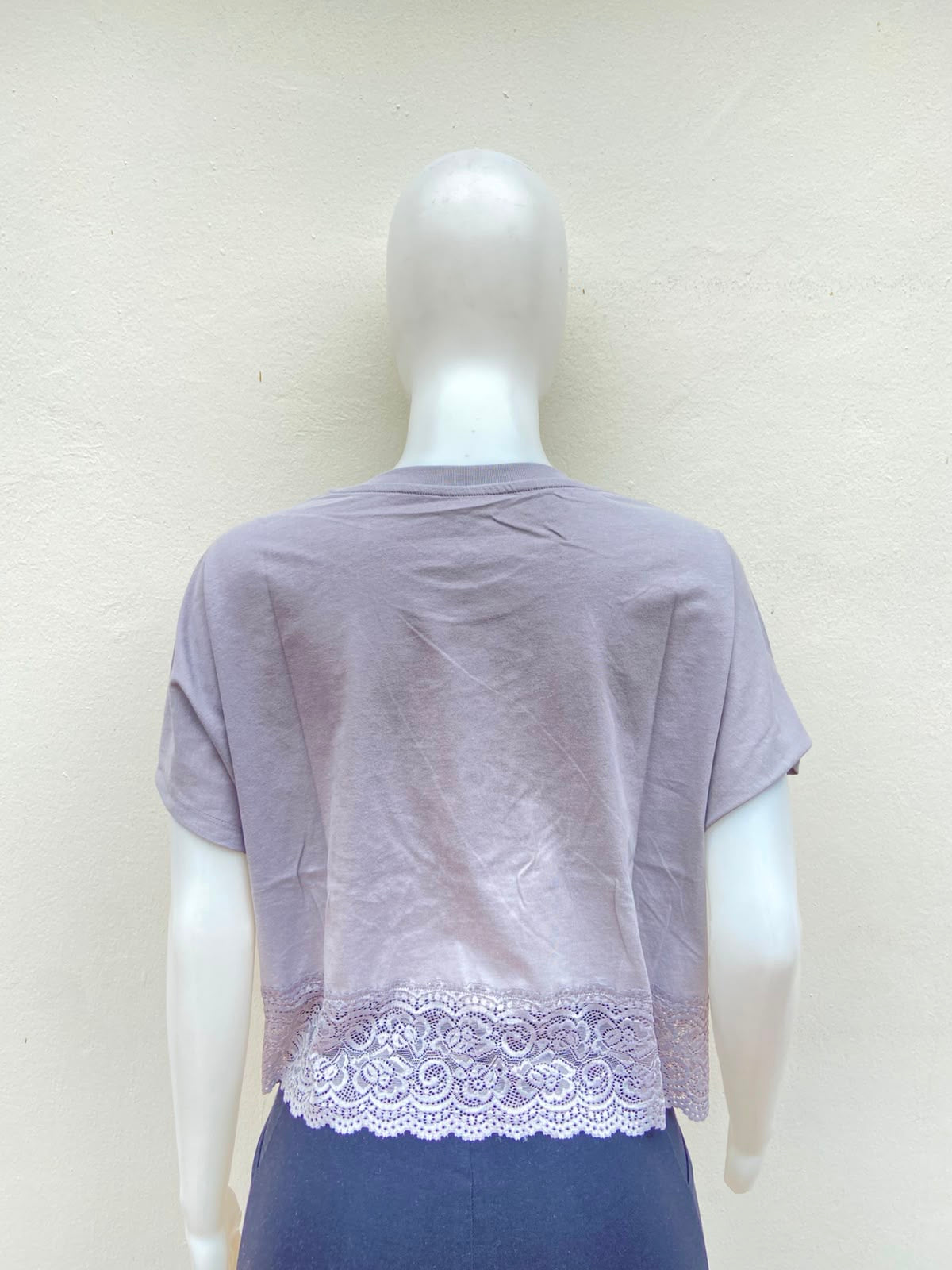 Crop-top gris con encaje abajo y estampado de la palabra Aaliyah en color azul y imagen.