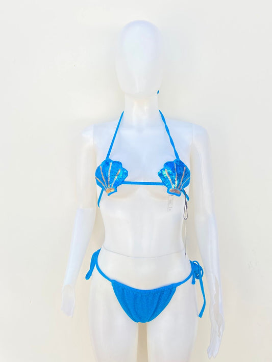 Biquini de dos piezas en color azul turquesa con tela brillante, brasier en forma de concha marina con detalles dorados y lazos ajustables.