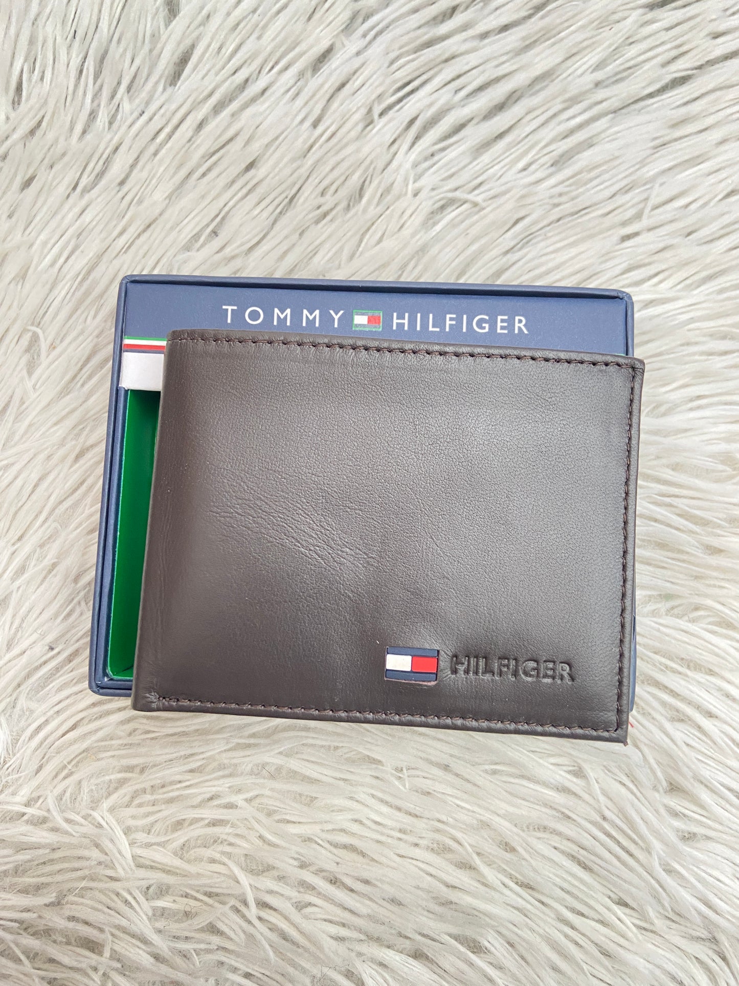 Billetera Tommy Hilfiger original marrón súper oscuro con letras HILFIGER al lado.