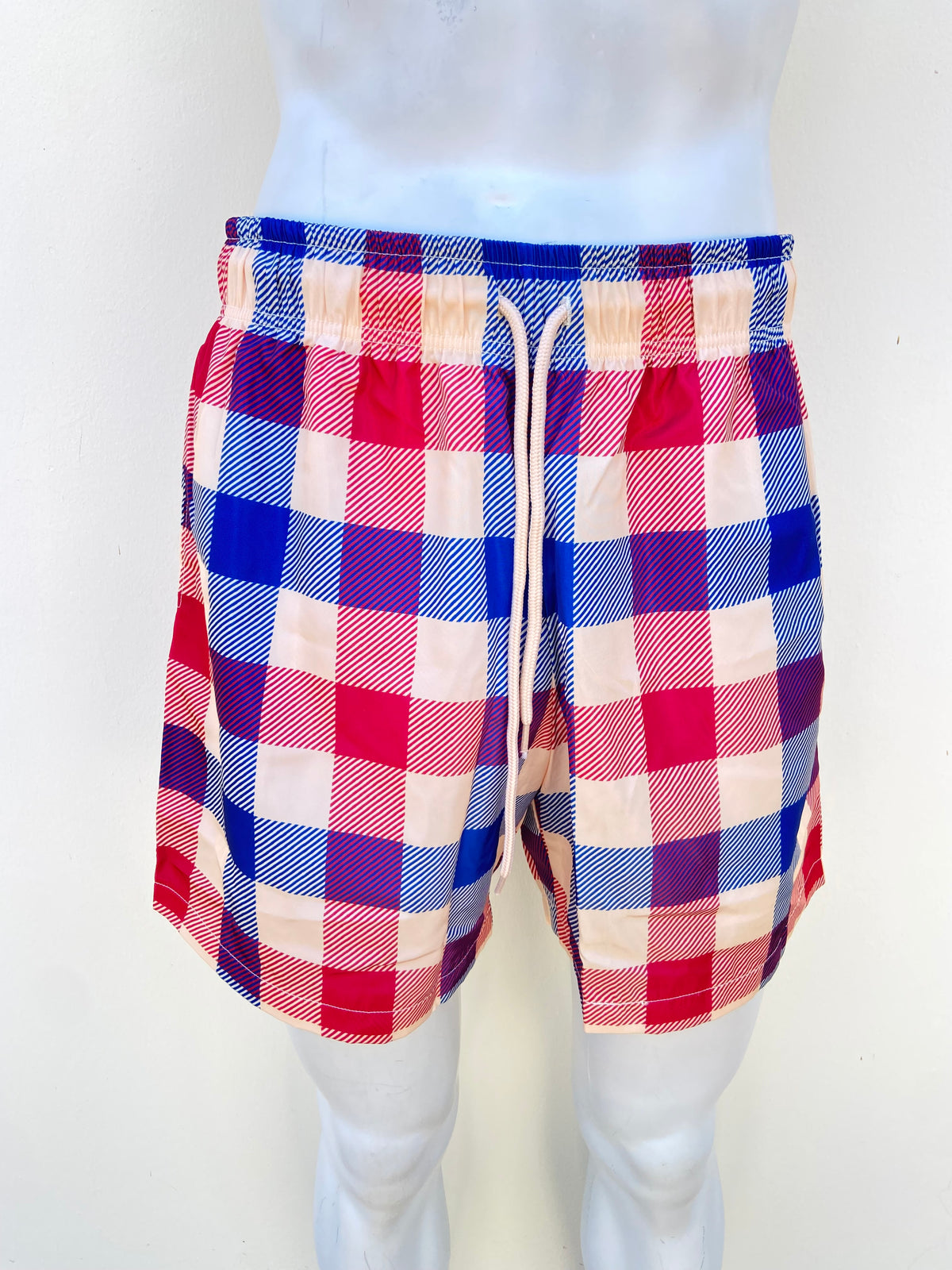 Bañador/ Baggy, crema con estampado de cuadros en color rojo y azul y lazos ajustables.