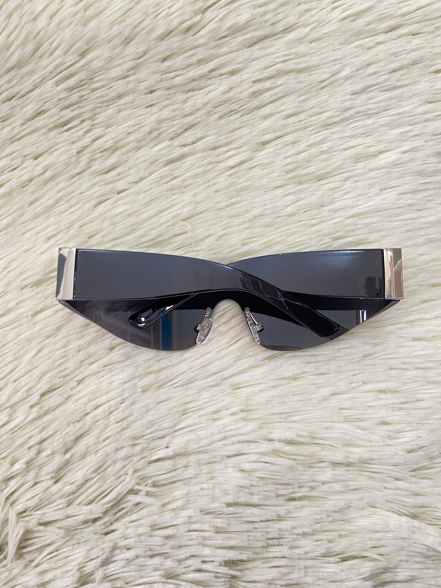 Lentes, negros curvos con detalles plateados en la montura.