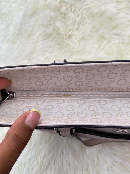 Cartera GUESS original, grande, rosado palo crema con letras G y placa GUESS en plateado en frente.