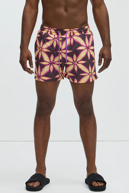 Bañador Baggy morado con estampado de una hoja amarilla.