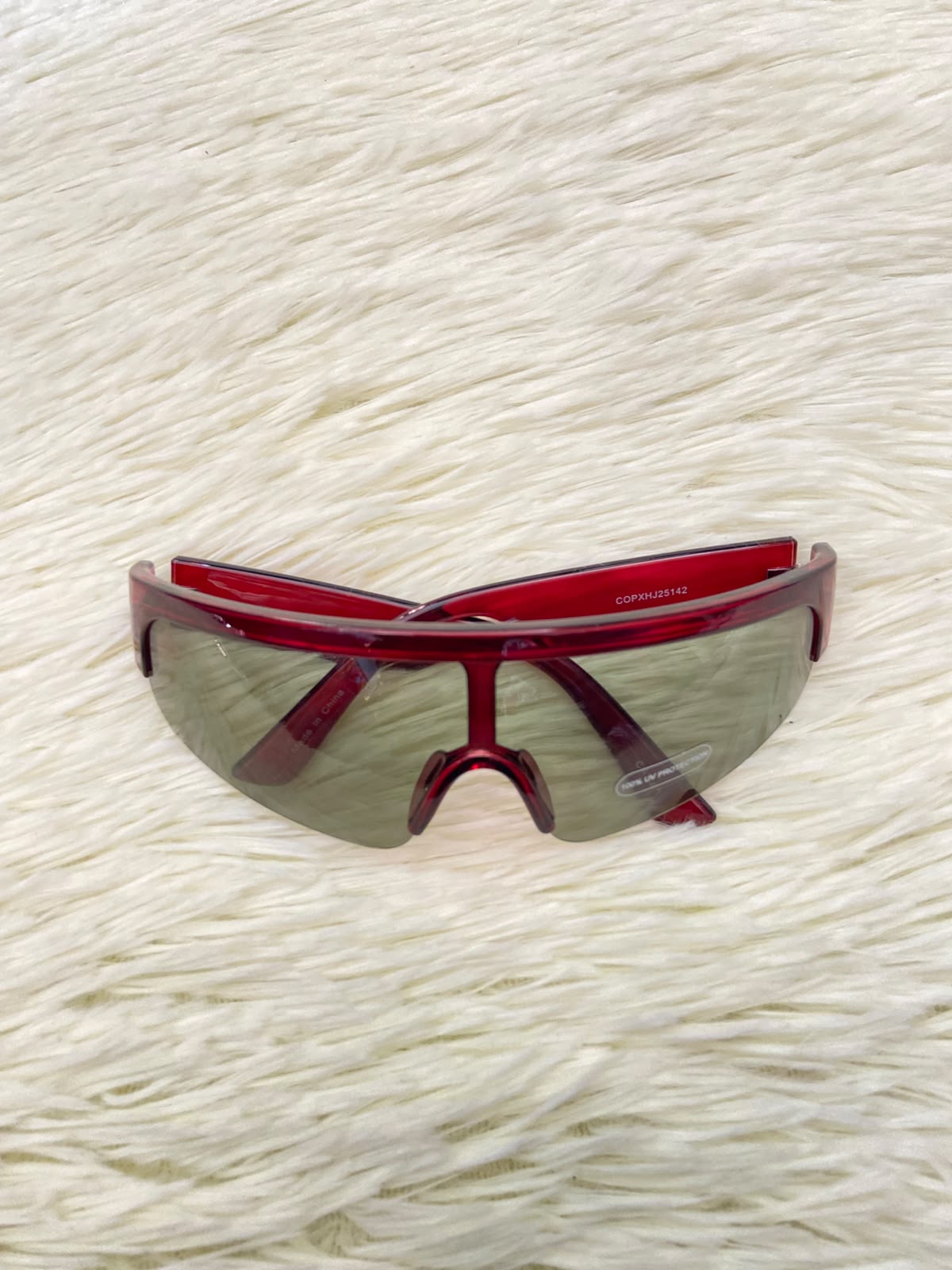 Lentes, verde oliva con montura en rojo vino y micas claras, con protección UV 100%.