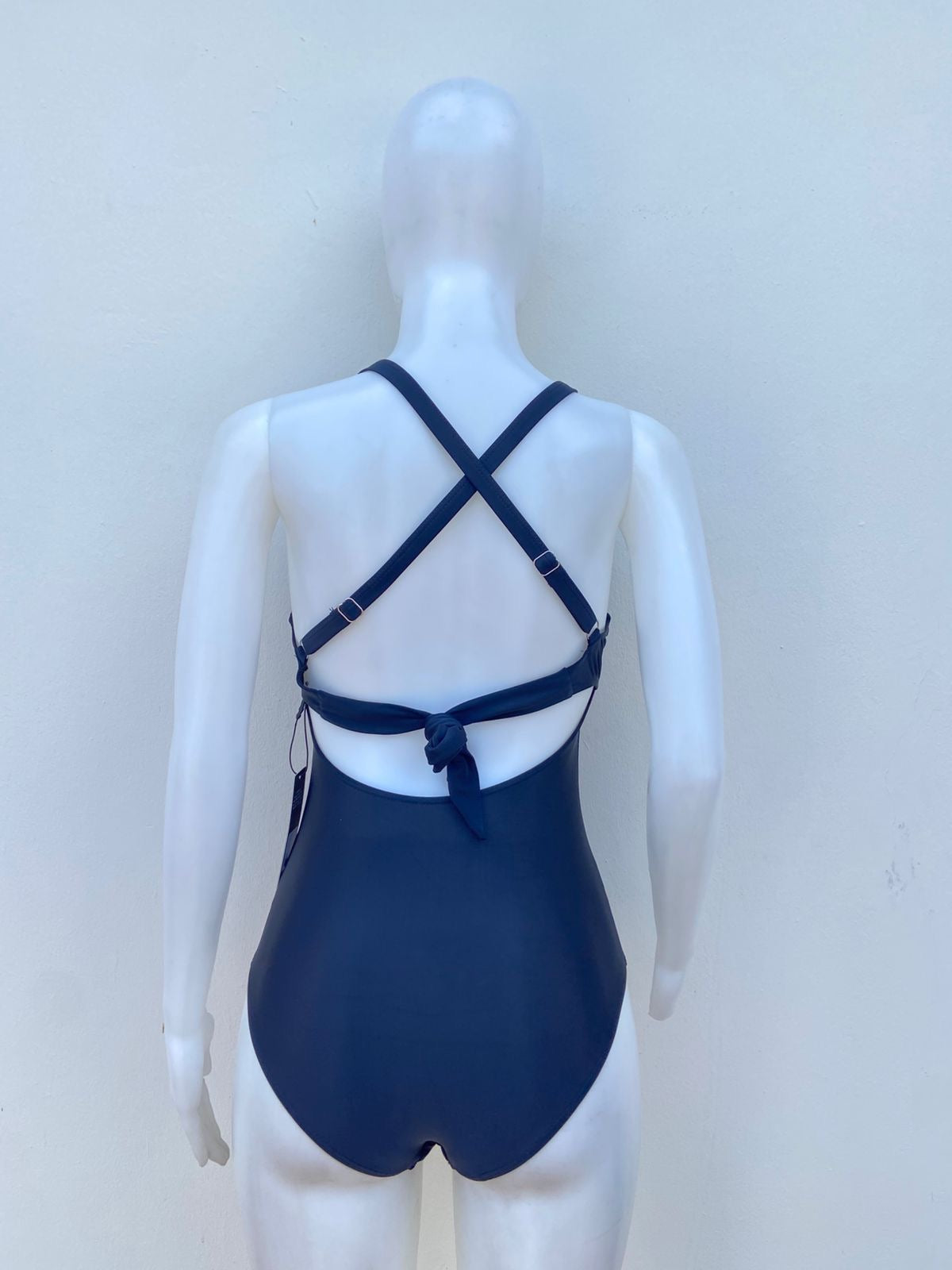 Biquini, negro liso con lazos ajustables en la eslpada y abierto en la parte delantera, una pieza.