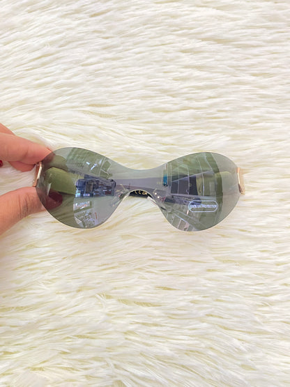 Lentes con micas verde y detalle en color dorado atrás.