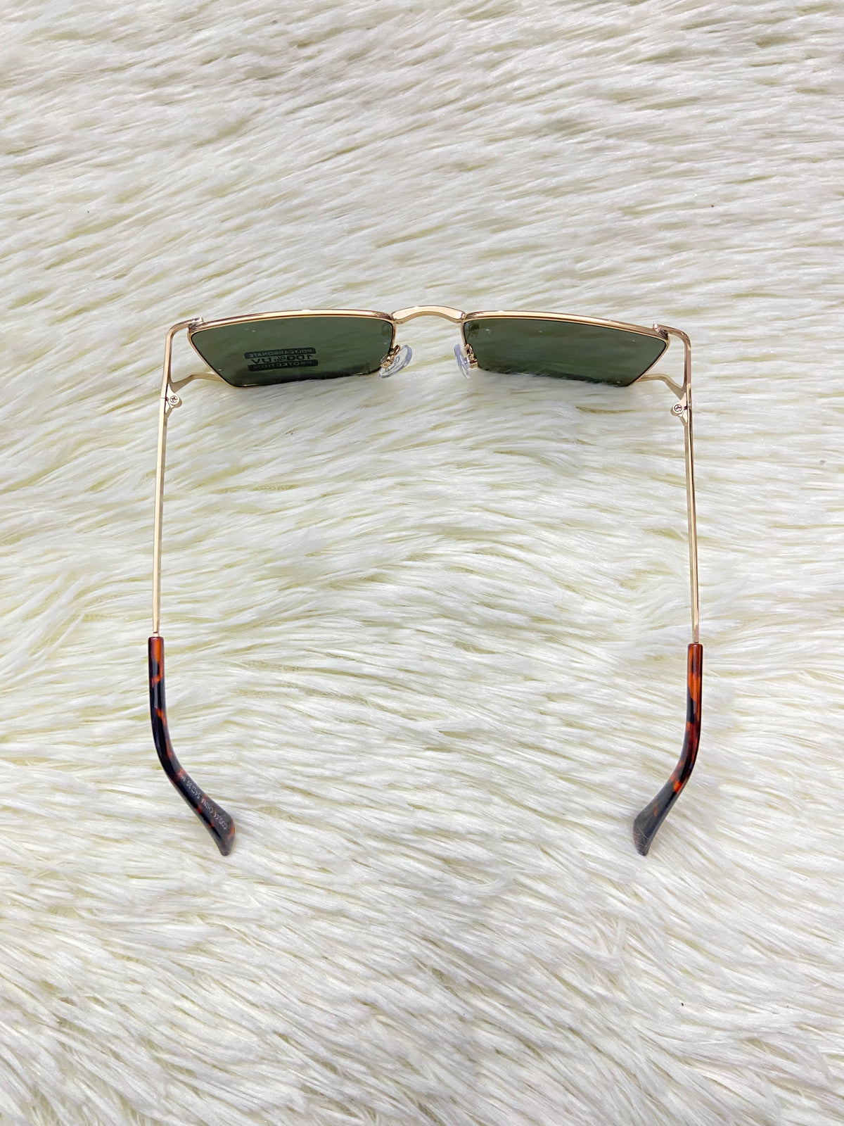 Lentes, con montura dorada y micas en color verde oscuro, con protección UV 100%.