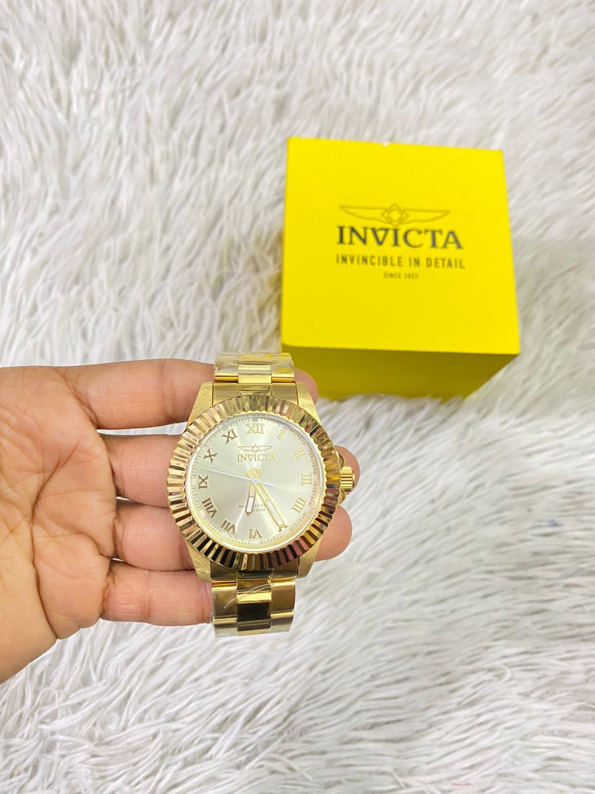 Reloj INVICTA original dorado con detalles en color blanco y letras INVICTA grabado en los lados.