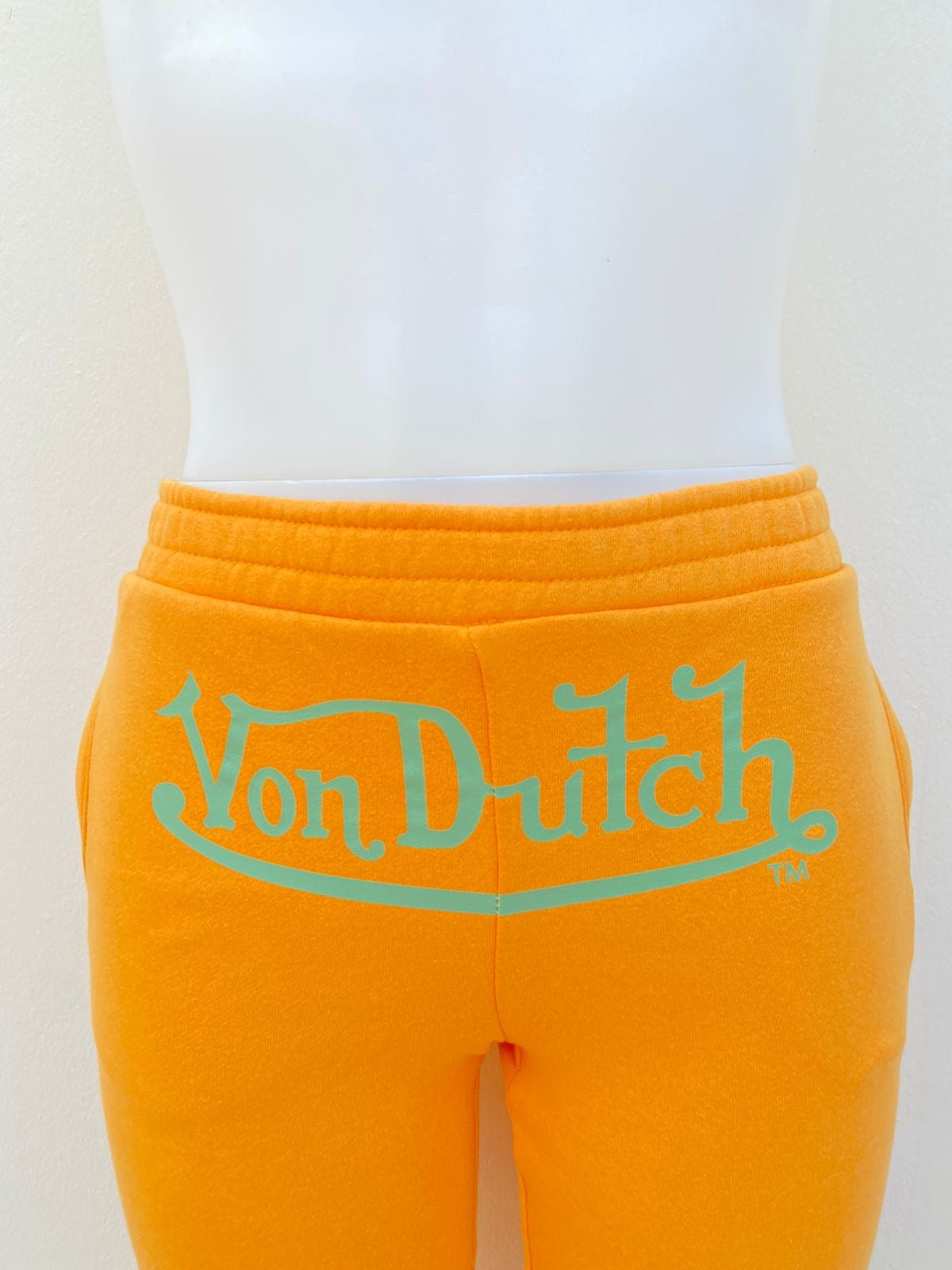 Pantalon VON DUTCH original Amarillo mostaza con letras de la marca en verde.