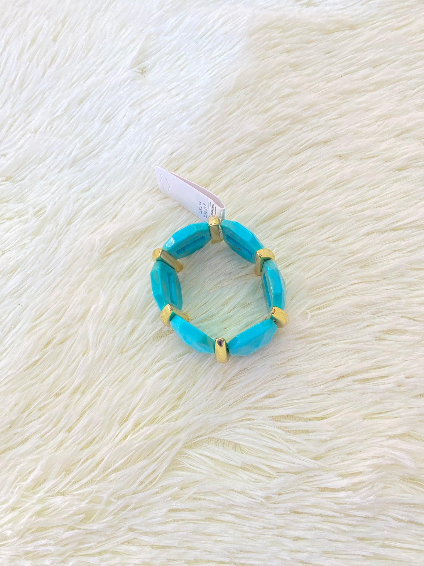 Pulsera en color azul turquesa con detalles dorados.