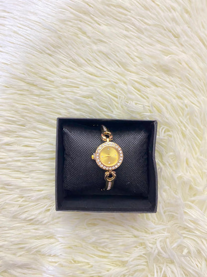Reloj, dorado con detalles de  diamantes.