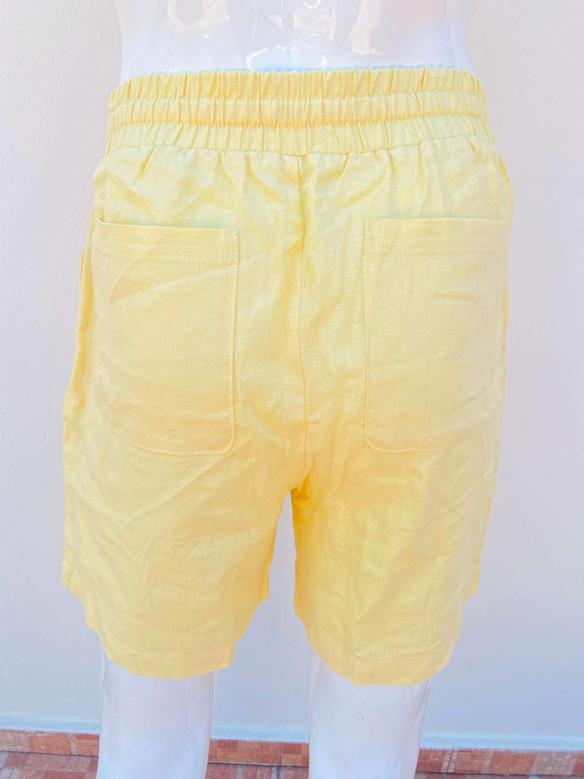 Bermuda, en color amarillo liso con lazo ajustables y bolsillos en los lados, 55% lino 45% algodón