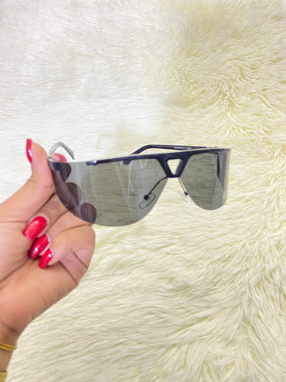 Lentes, negro con montura negro matte y triángulo en frente, protección UV 400.